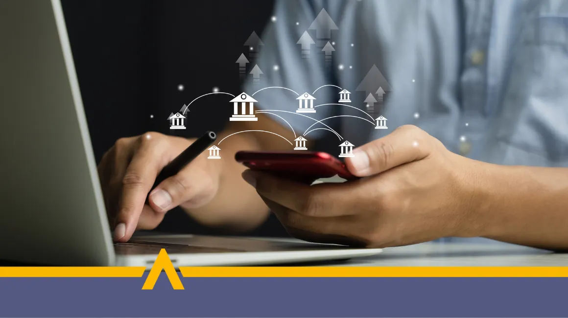 Osoba wykonująca przelew bankowy za pomocą smartfona i laptopa